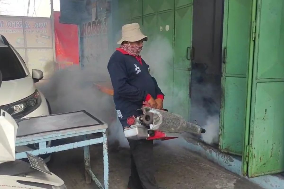 SEMPROT—Petugas Dinas Kesehatan Kabupaten Madiun menyemprot asap di lokasi yang terdampak penyakit demam berdarah. Pengasapan dilakukan untuk mematikan sarang nyamuk di daerah-daerah yang ditemukan kasus DBD.