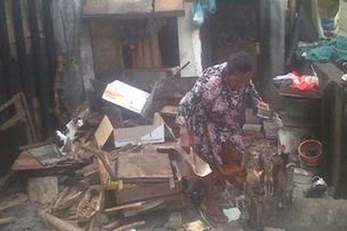 Nenek Rum saat memberi makan kucing peliharaannya di depan gubuknya, Jumat (26/10/2012). Gubuk yang telah ditempati selama puluhan tahun tersebut terletak di sisi Pintu Air Manggarai.