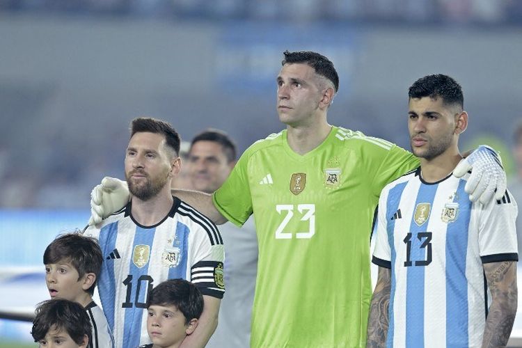 Lionel Messi (kiri) berbaris di sebelah Emiliano Martinez (tengah) dan Cristian Romero (kanan) dalam laga uji coba Argentina vs Panama di Estadio Monumental, Buenos Aires, Jumat 24 Maret 2023. (Photo by JUAN MABROMATA / AFP)