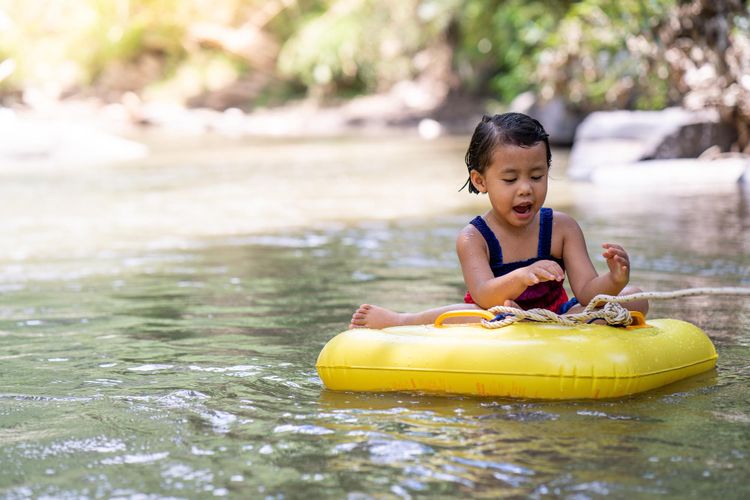 Ilustrasi anak berenang di sungai.