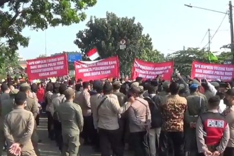 Petugas gabungan mengamankan jalannya kegiatan penolakan pengosongan lahan di Cakung, Jakarta, Kamis (11/8/2022). 