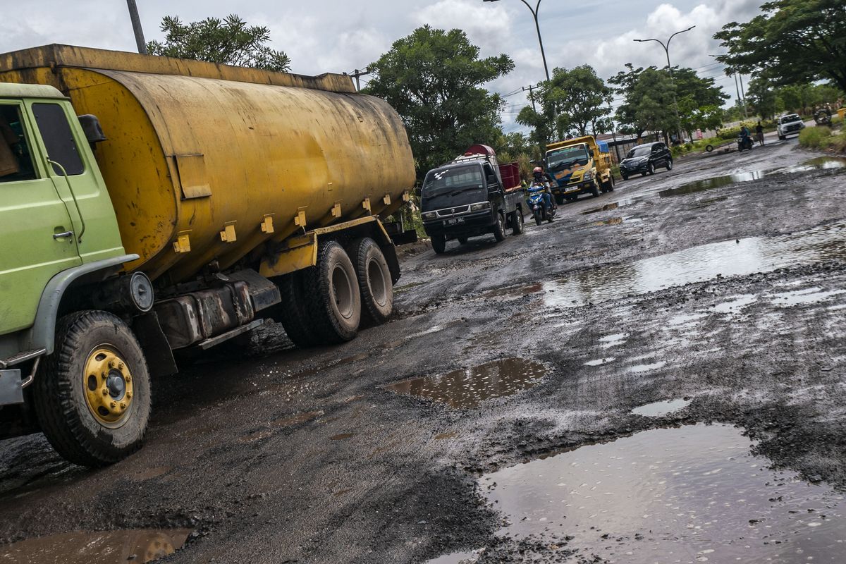 Pengendara kendaraan bermotor menghindari jalan berlubang di Jalan Lingkar Selatan, Kota Cilegon, Banten, Sabtu (1/4/2023). Jalan utama menuju pelabuhan Ciwandan tersebut kondisinya berlubang dan rusak parah hingga foto ini diambil belum diperbaiki oleh pemerintah setempat. 