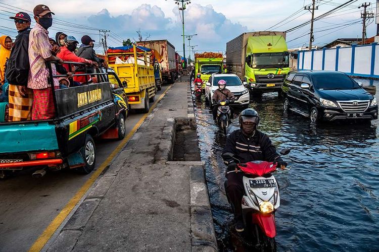 Kendaraan bermotor menembus jalan raya pantura Demak KM 8 ruas Demak-Semarang yang terendam limpasan air laut ke daratan (rob) di Demak, Jawa Tengah, Rabu (13/5/2020). Banjir rob yang melimpas ke jalur utama pantura Demak setinggi 15-40 sentimeter itu menyebabkan kemacetan lalu lintas sepanjang sekitar 7,5 kilometer dari Kabupaten Demak menuju Kota Semarang dan sekitar 1 kilometer dari Kota Semarang menuju Kabupaten Demak.