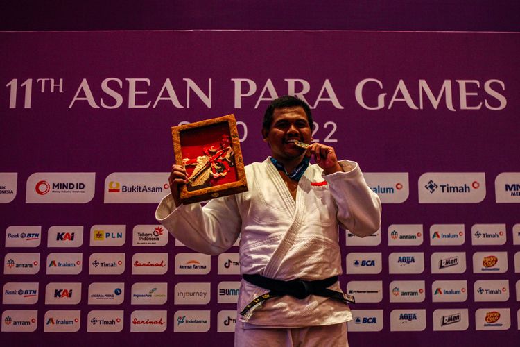 Atlet blind judo Indonesia, Fajar Pambudi, merayakan kemenangannya dalam meraih medali emas ASEAN Para Games 2022 kelas -90 kg di Convention Hall Tirtonadi, Rabu (3/8/2022).