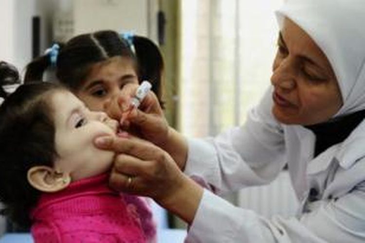 Seorang pekerja kesehatan tengah memberikan imunisasi polio untuk seorang anak di pusat kesehatan Abou Dhar Al Ghifari di Damaskus. Wabah polio pecah di Suriah setelah sejak 1999 negeri itu dinyatakan bebas dari polio. Akibatnya, PBB meluncurkan gerakan imunisasi polio untuk 20 juta anak di tujuh negara Timur Tengah.