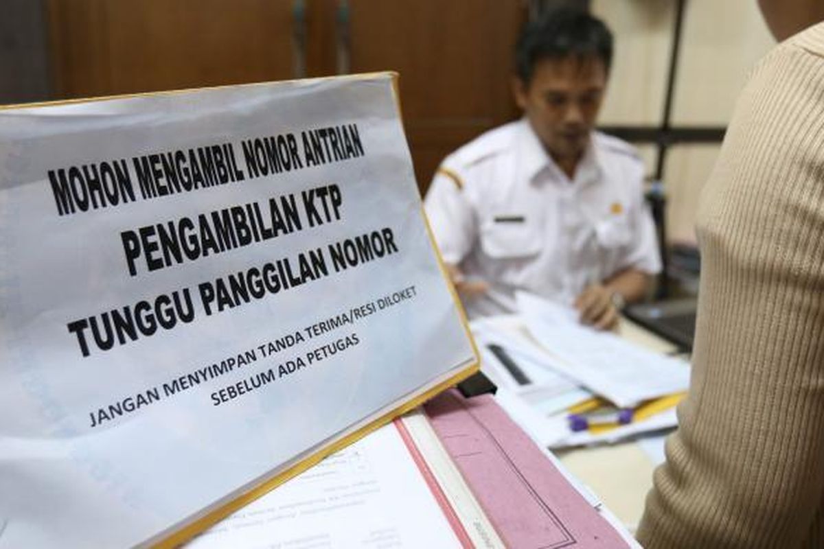 Salah seorang petugas terlihat sedang membantu warga dalam pembuatan kartu keluarga dan KTP di kantor Dinas Kependudukan dan Pencatatan Sipil di Tigaraksa Tangerang, Senin (31/8/2016). Sebagian besar warga mengurus e-KTP, KK, dan akta kelahiran.