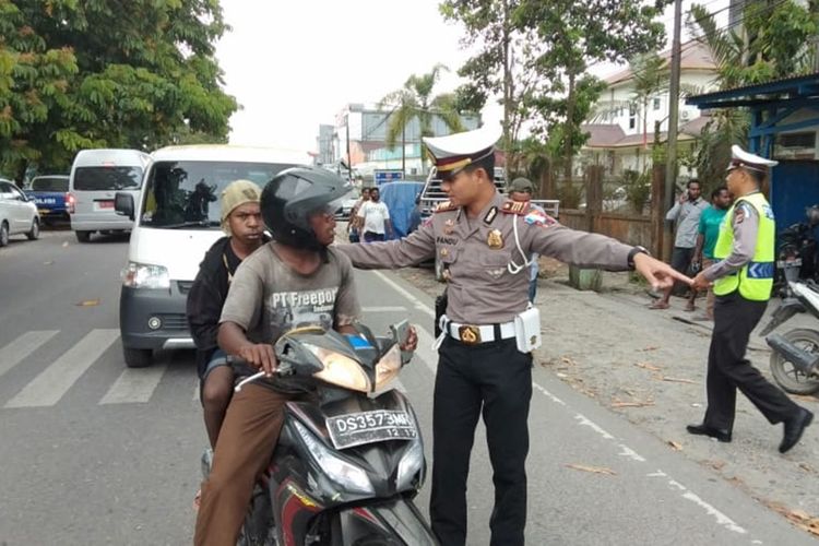 Polisi ketika menghentikan pengendara yang membonceng penumpangnya tanpa menggunakan helm, Rabu (23/10/2019)