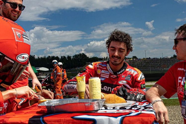 Selebrasi Francesco Bagnaia makan hot dog di pinggir trek, setelah menang pada MotoGP Italia 2023 di Sirkuit Mugello