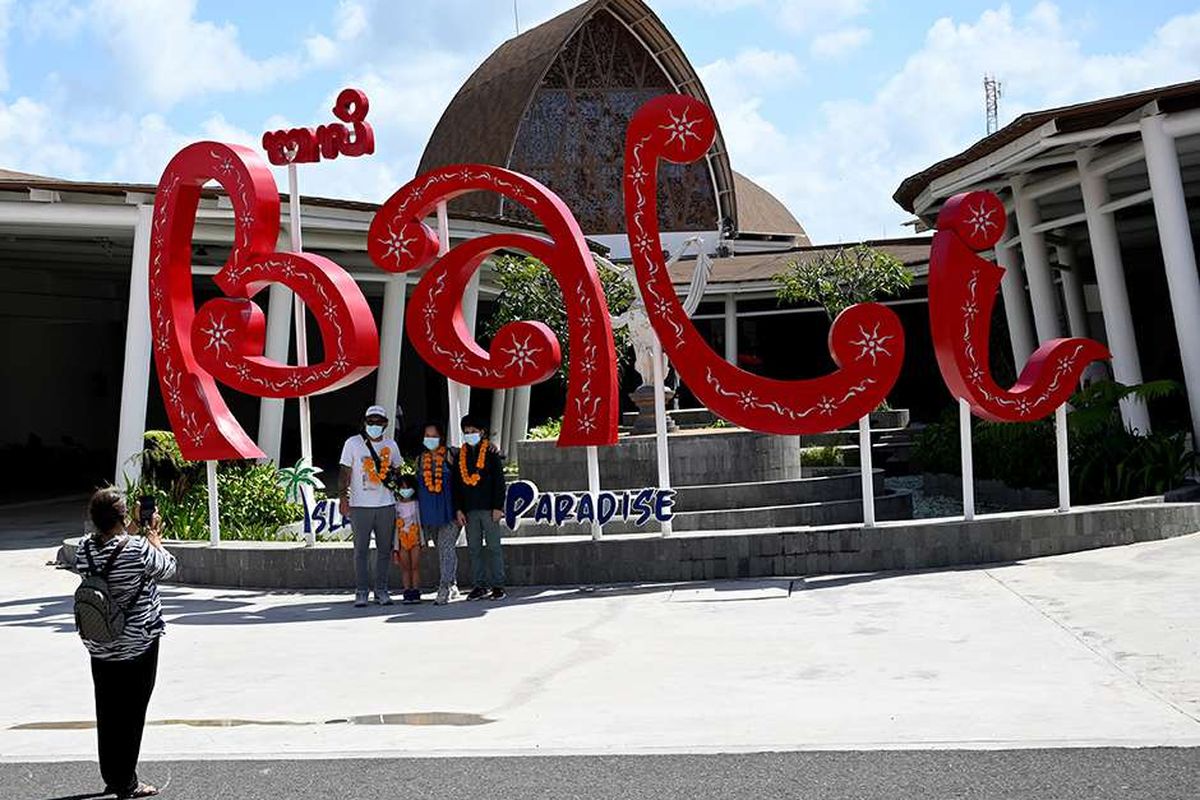 Penumpang berfoto di Bandara Internasional I Gusti Ngurah Rai, Badung, Bali, pada hari pertama dibukanya kembali kunjungan wisatawan domestik, Jumat (31/7/2020). Pemerintah Provinsi Bali mulai membuka sektor pariwisata bagi wisatawan domestik pada Jumat (31/7) dengan sejumlah persyaratan yang mengedepankan aspek kesehatan dan kualitas untuk memberi pelindungan, kenyamanan dan keamanan bagi wisatawan yang berkunjung selama masa pandemi Covid-19.