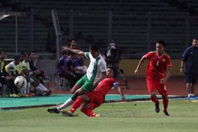 Pemain Indonesia U-19 Muhammad Dimas Drajad (kiri) diganjal pemain Myanmar U-19 NandaKyaw (tengah) dalam pertandingan persahabatan di Stadion Utama Gelora Bung Karno, Jakarta, Rabu (7/5/2014). Pertandingan yang diwarnai dengan 2 kartu merah untuk kedua tim tersebut berakhir untuk kekalahan Indonesia dengan skor 1-2. 