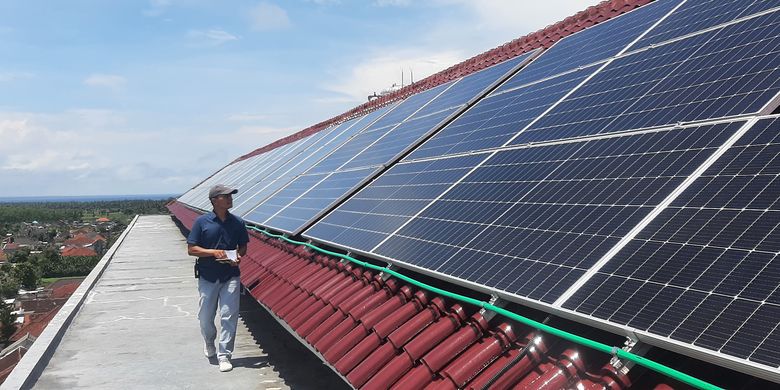 Seorang staf memeriksa kondisi panel surya di atap Hotel Santika Banyuwangi, yang berlokasi di Kelurahan Sobo, Kecamatan/Kabupaten Banyuwangi, yang mulai memanfaatkan energi baru terbarukan, Rabu (28/12/2022).