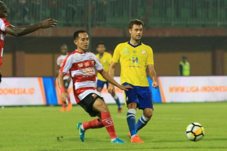 Gelandang Madura United, Slamet Nurcahyo (kiri), dibayangi oleh pengatur serangan Barito Putera, Douglas Packer (kanan), dalam laga kedua pada pekan pertama Liga 1 musim 2018 di Stadion Gelora Bangkalan, Senin (26/3/2018).