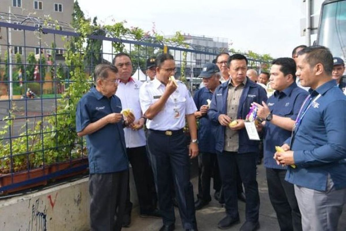 Wakil Presiden Jusuf Kalla bersama sejumlah menteri dan panitia penyelenggara Asian Games 2018 (Inasgoc), meninjau Kali Sentiong di sebelah Wisma Atlet Kemayoran, Jakarta Pusat, Jumat (3/8/2018), sambil makan pisang. 