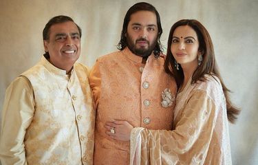 Miliarder India, Mukesh Ambani, dan istrinya, Nita Ambani, mengapit putra mereka, Anant Ambani, pada sesi foto, Sabtu (2/3/2024), dalam rangkaian pesta prapernikahan Anant Ambani dan Radhika Merchant di Jamnagar, India.