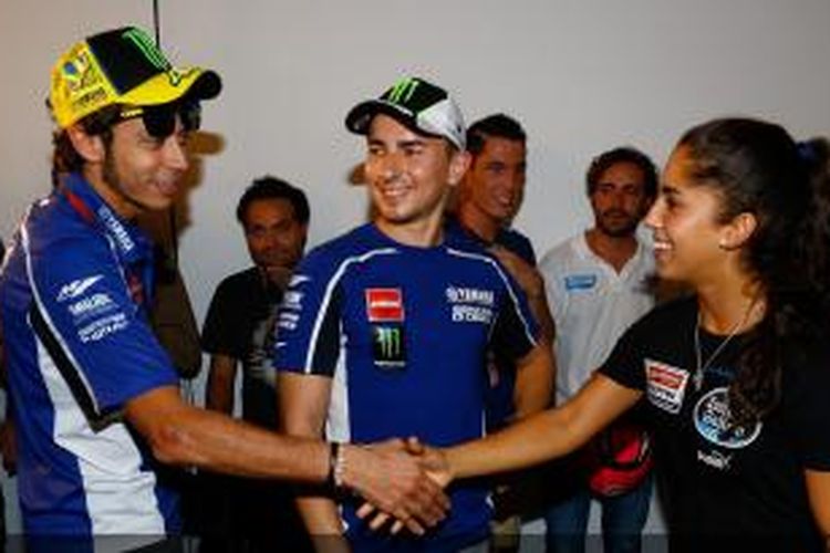 Pebalap Yamaha Factory Racing asal Italia, Valentino Rossi (kiri) menyalami pebalap Spanyol, Maria Herrara yang akan turun di kelas Moto3 GP Aragon, disaksikan oleh Jorge Lorenzo (tengah). Mereka bertemu saat konferensi pers jelang GP Aragon, Kamis (26/9/2013).