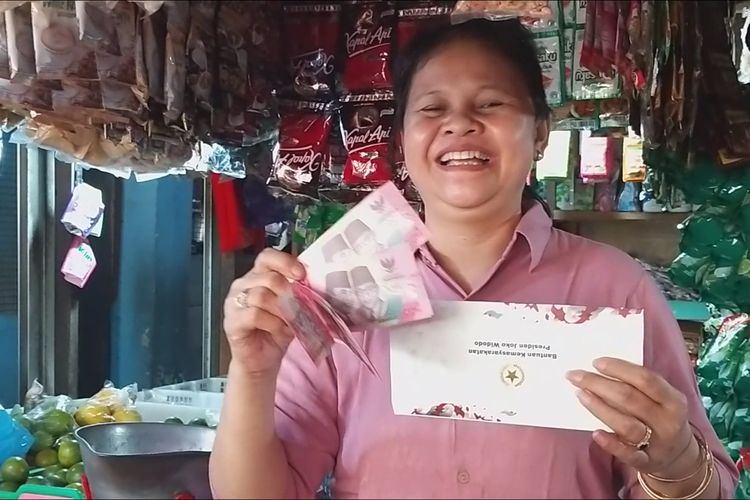 TERIMA UANG—Sumini, salah satu pedagang sembako Pasar Kota Wonogiri menunjukkan uang bantuan pemberian Presiden Joko Widodo saat berkunjung ke pasar itu, Kamis (1/2/2024).