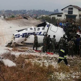 Tim penyelamat dan tentara berada di sekitar pesawat milik maskapai US-Bangla yang mengalami kecelakaan di bandara Tribuvhan, Kathmandu, Nepal, Senin (12/3/2018).
