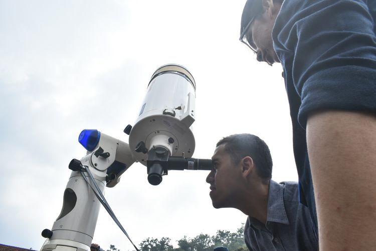 Warga tampak berbaris bergiliran untuk melihat gerhana matahari melalui 4 teleskop yang disediakan Observatorium Boscha di Lapang Sinapeul, Desa Gudang Kahuripan, Kecamatan Lembang, Kabupaten Bandung Barat, Kamis (26/12/2019).