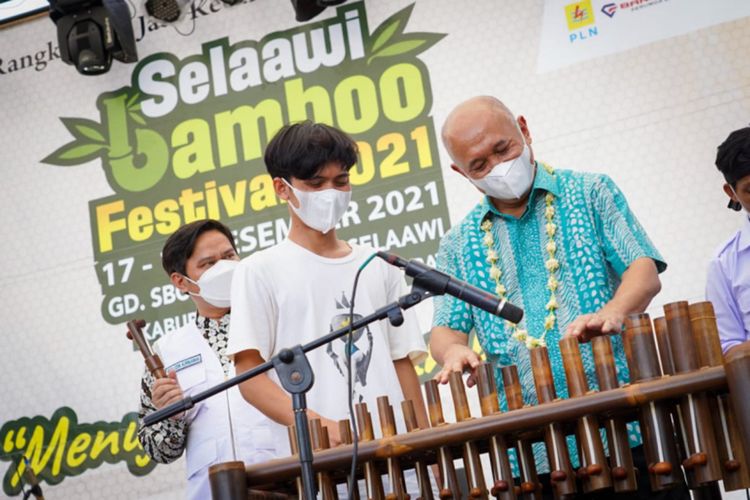 Menkop UKM Teten Masduki memainkan alat musik Celentung yang dikembangkan oleh pengrajin bambu di Kecamatan Selaawi saat membuka event Selaawi Bambu Festival, Sabtu (17/12/2021)