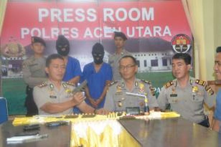 Kapolres Aceh Utara AKBP Achmadi (kiri) memperlihatkan barang bukti pistol di Mapolres Aceh Utara, Rabu (16/9/2015)
