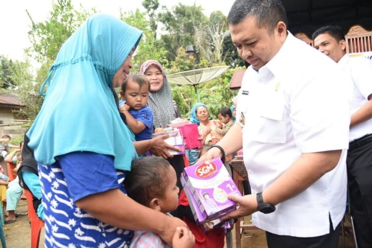 Bupati Tapsel Dolly P Pasaribu saat membagikan susu formula kepada anak sebagai upaya menurunkan angka stunting di wilayahnya.