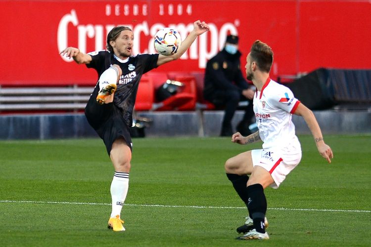 Luka Modric (kiri) berebut bola dengan Ivan Rakitic dalam laga Sevilla vs Real Madrid pada pekan ke-12 Liga Spanyol di Stadion Ramon Sanchez Pizjuan, Sabtu (5/12/2020) malam WIB. 