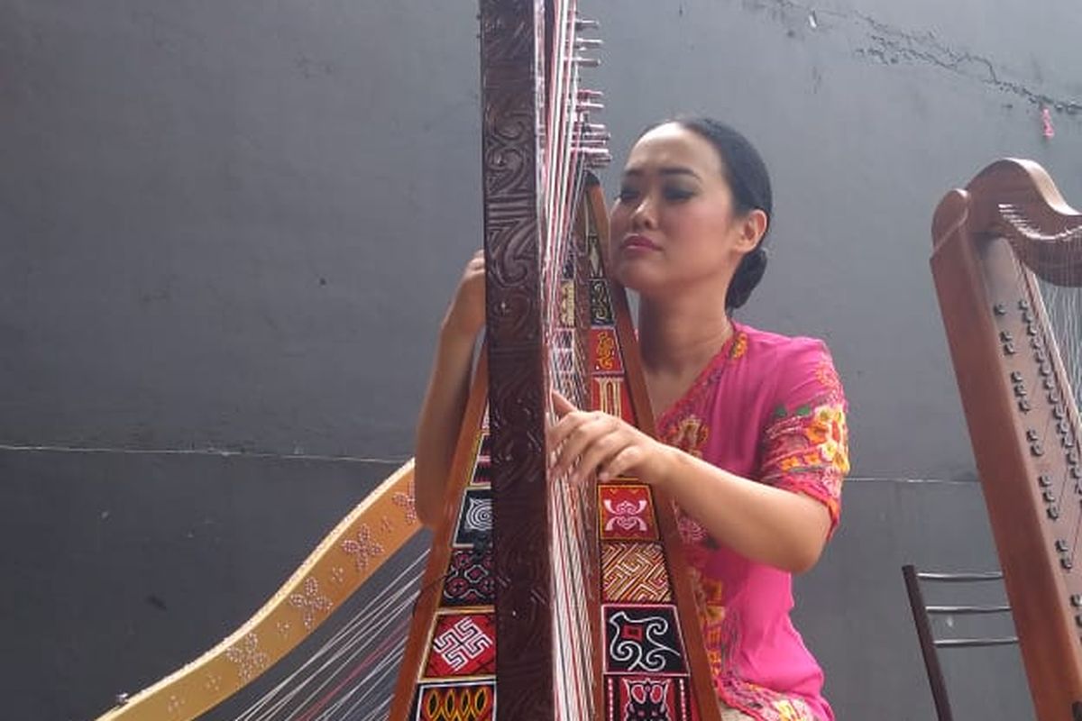 Musisi asal Bandung, Sisca, tengah memainkan harpa toraja. 