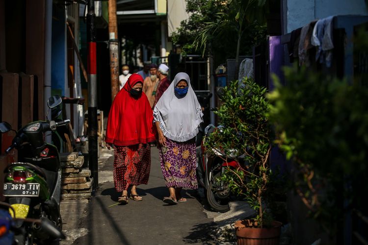 Dua warga menggunakan masker berjalan di gang di kawasan Kebon Pala, Jakarta Timur, Senin (5/10/2020). Pembatasan sosial berskala besar (PSBB) di Jakarta untuk mengendalikan penularan Covid-19 telah memasuki pekan ketiga.