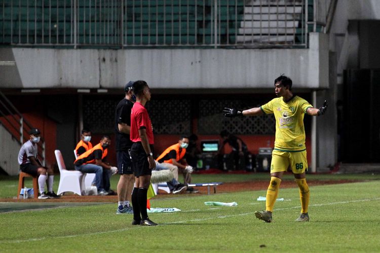 Penjaga gawang Persebaya Surabaya Satria Tama melakukan protes kapada basit seusai diganjar kartu merah saat laga melawan Persib Bandung pada babak 8 besar Piala Menpora 2021 yang berakhir dengan skor 3-2 di Stadion Maguwoharjo Sleman, Minggu (11/04/2021) malam.
