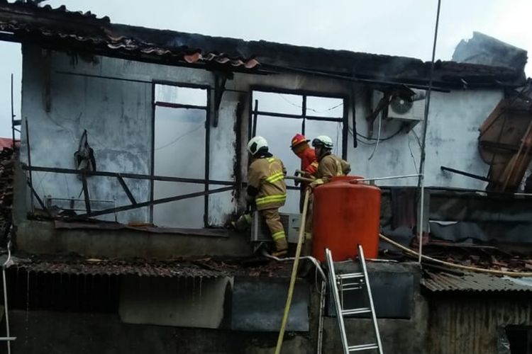 Petugas Sudin PKP Jakarta Timur saat berupaya memadamkan api yang membakar rumah di Jalan Bacang 1, Kelurahan Lubang Buaya, Cipayung, Jakarta Timur, Kamis (20/2/2020).