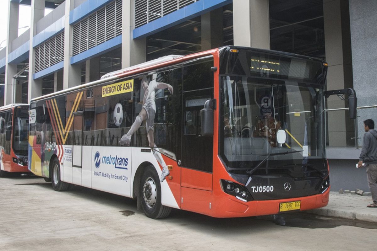 Calon penumpang berjalan di dekat bus Metrotrans saat uji coba integrasi dengan Kereta Bandara pada hari pertama di Stasiun Sudirman Baru, Jakarta, Kamis (28/12/2017). Integrasi Metrotrans dengan Kereta Bandara itu bertujuan untuk memberikan kenyamanan kepada masyarakat.  