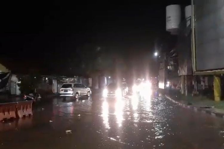 Petugas dari Satlantas Polres Pasuruan Kota sedang melakukan pengalihan arus lalu lintas guna menghindari genangan air yang meluap di atas jembatan Buk Wedi, Jum'at malam (6/12/2024) 