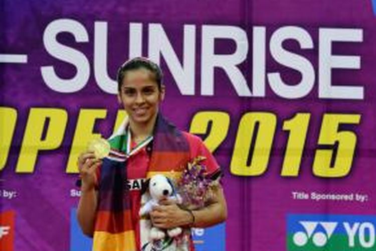 Pebulu tangkis India, Saina Nehwal, berpose dengan medali emas yang didapat setelah memenangi laga final India Terbuka melawan petenis Spanyol, Carolina Marin, di Siri Fort Sports Complex, Minggu (29/3/2015).