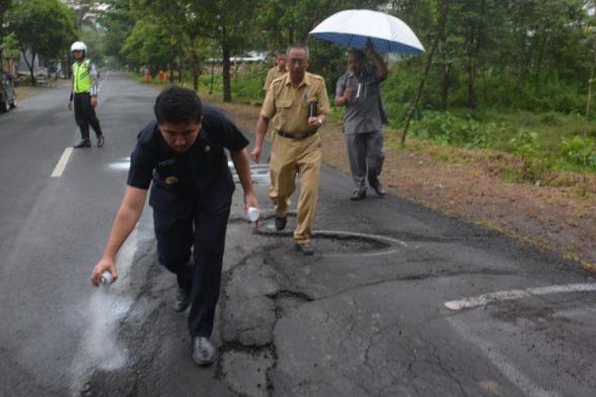 Bupati Trenggalek Emil Elestianto Dardak menandai jalan rusak dengan cat semprot di jalan Brigjen Soetran kabupaten Trenggalek (13/02/2017).
