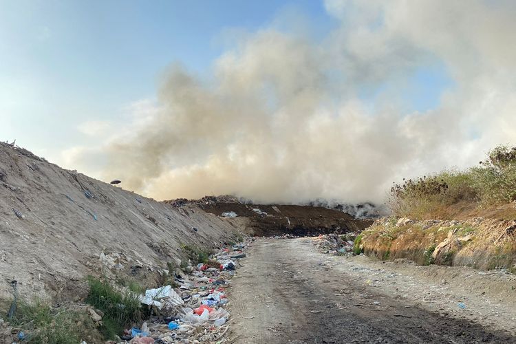 Asap tebal mengepul dari sela-sela tumpukan sampah di Tempat Pembuangan Akhir (TPA) Suwung Kangin, Kelurahan Sesetan, Kecamatan Denpasar Selatan, Kota Denpasar, Bali, pada Jumat (13/10/2023).
