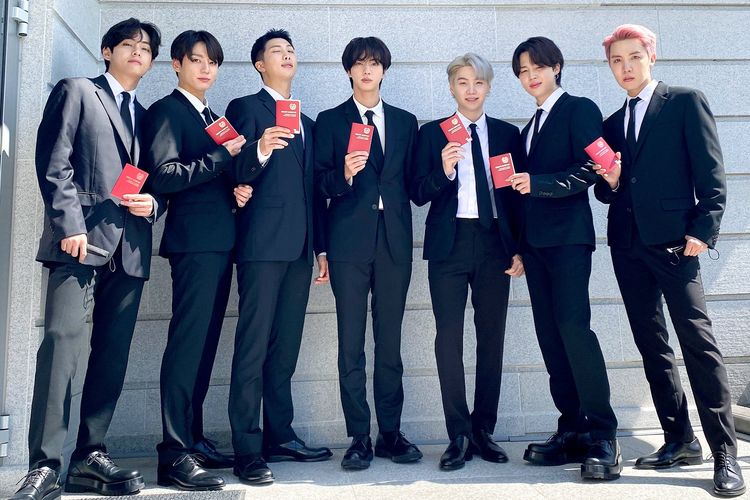Para member BTS (dari kiri) V, Jungkook, RM, Jin, Suga, Jimin, dan J-Hope menunjukkan paspor diplomatik yang mereka terima dari Presiden Korea Selatan Moon Jae In di Kantor Kepresidenan, Selasa (14/9/2021).