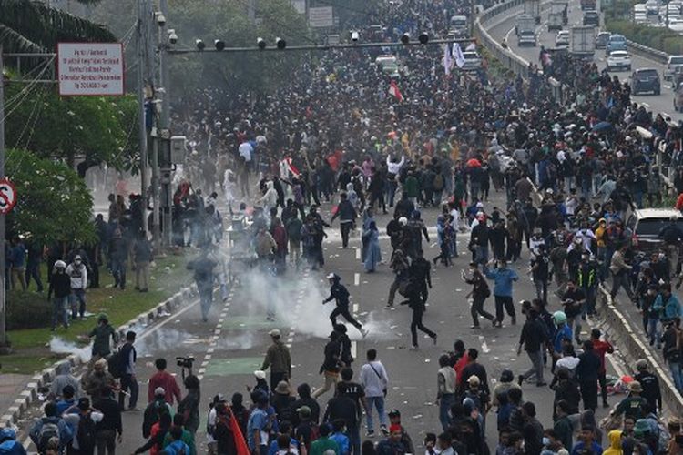 Police fire tear gas canisters at students during a rally against moves to extend the presidential mandate in Jakarta on April 11, 2022. (Photo by ADEK BERRY / AFP)