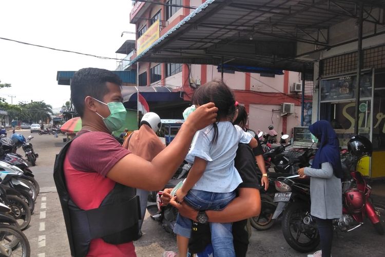 Anggota Polres Tanjung Pinang membagikan ribuan masker ke warga, Selasa (17/9/2019). Sedikitnya ada 5 posko disiagakan untuk penanggulangan kabut asap di Kota Tanjung Pinang yang disebabkan mulai dari kabut asap kiriman hingga dari kebakaran hutan dan lahan (karhutla) yang terjadi di Kepri.