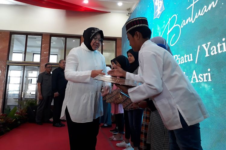 Wali Kota Surabaya Tri Rismaharini menyerahkan bantuan pendidikan kepada anak yatim piatu eks lokalisasi Tambak Asri di Balai Kota Surabaya, Selasa (27/8/2019).
