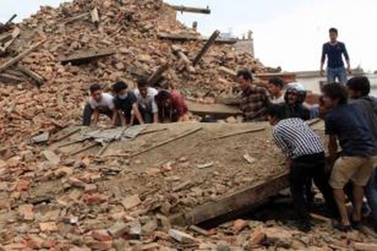 Warga berupaya membersihkan puing reruntuhan bangunan pasca-gempa berkekuatan 7.9 SR di Hanumandhoka Durbar Square, Kathmandu, Nepal, 25 April 2015.