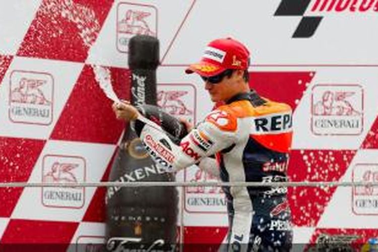 Pebalap Repsol Honda asal Spanyol, Dani Pedrosa, menyempotkan champagne di atas podium Sirkuit Valencia, setelah memenangi GP Valencia, Minggu (11/11/2013).