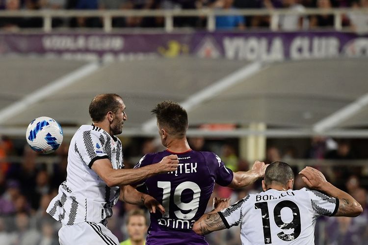 Bek Juventus Giorgio Chiellini (kiri) berduel dengan penyerang Fiorentina Krzysztof Piatek pada laga yang termasuk dalam rangkaian pekan terakhir Liga Italia 2021-2022 di Stadion Artemio-Franchi, Minggu (22/5/2022) dini hari WIB.