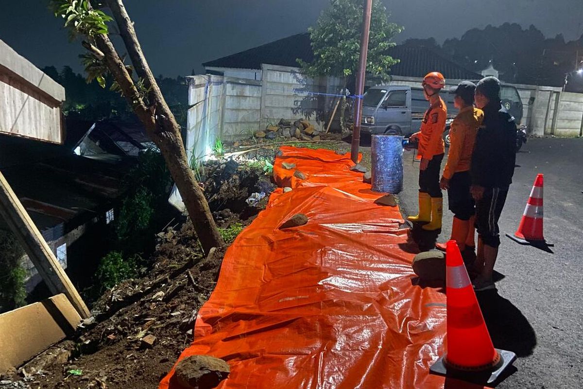 Kondisi tebing penahan tanah Mako Pusdik Reskrim longsor hingga membuat akses jalan terancam dan aliran kali tertimbun di kawasan Puncak Bogor, tepatnya Desa Megamendung.