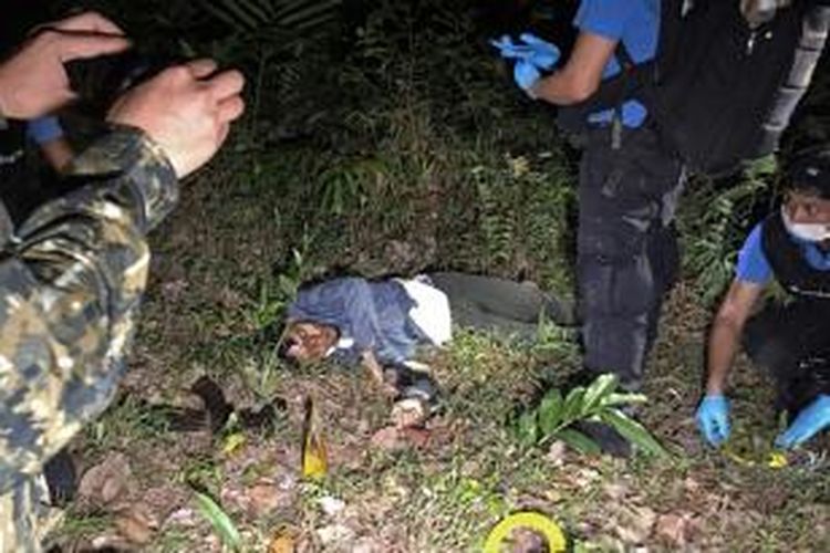 Militer Thailand memeriksa salah seorang korban tewas dalam bentrokan di sebuah desa di Provinsi Pattani, Rabu (25/3/2015) malam.