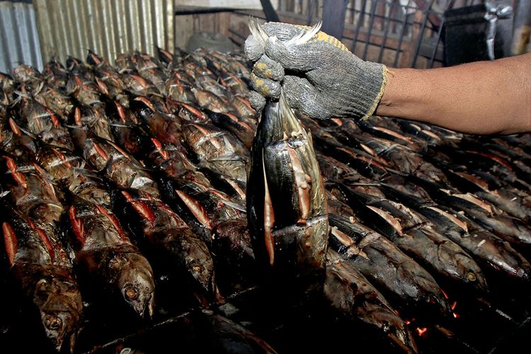 Pedagang menunjukkan ikan asar di Pasar Sentral Hamadi, Jayapura, Papua.