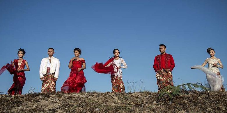 Model mengenakan busana tradisional bertema merah putih saat fashion show di tanggul Lapindo Porong, Sidoarjo, Jawa Timur, Selasa (13/8/2019). Peragaan busana yang menampilkan busana kebaya tersebut untuk memeriahkan HUT ke-74 kemerdekaan RI.