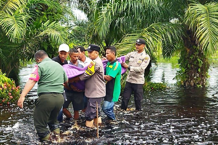 Petugas kepolisian bersama TNI dan warga mengevakuasi salah seorang korban banjir yang sedang sakit, di Kecamatan Bantan, Kabupaten Bengkalis, Riau, Kamis (30/11/2023).