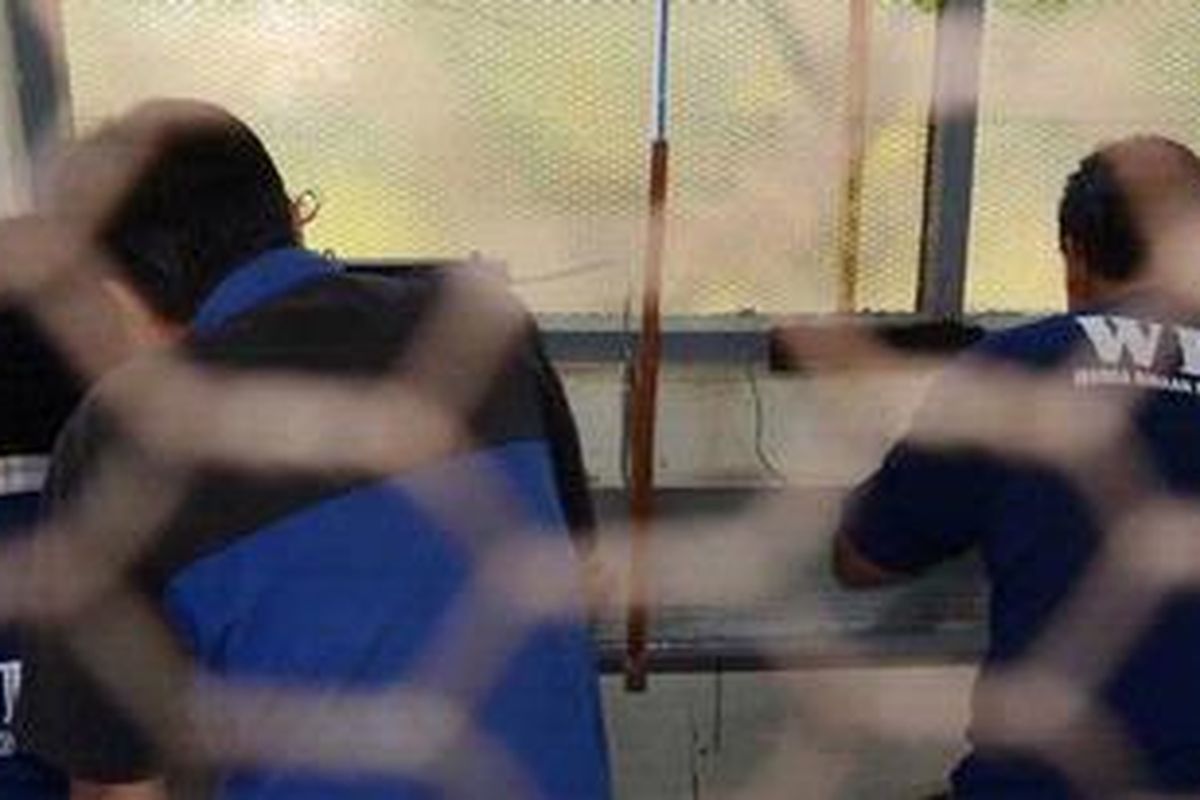 Sejumlah narapidana menggunakan fasilitas telepon di dalam LP Cebongan di Desa Sumberadi, Mlati, Sleman, DI Yogyakarta, Senin (25/3/2013). Berbagai aktivitas di lapas tersebut telah berangsur normal pasca-penyerbuan gerombolan bersenjata api tiga hari sebelumnya yang mengakibatkan empat tahanan tewas. KOMPAS/FERGANATA INDRA RIATMOKO