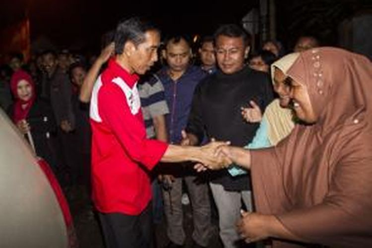 Calon presiden dari Partai Demokrasi Indonesia Perjuangan (PDI-P), Joko Widodo (kiri), menyapa warga dalam kunjungannya ke Sukabumi, Jawa Barat, Kamis (27/3/2014). Pria yang akrab disapa Jokowi meminta kepada masyarakat agar memberikan dukungan kepada PDI-P sekaligus turut mengawasi pelaksanaan Pemilu 2014.