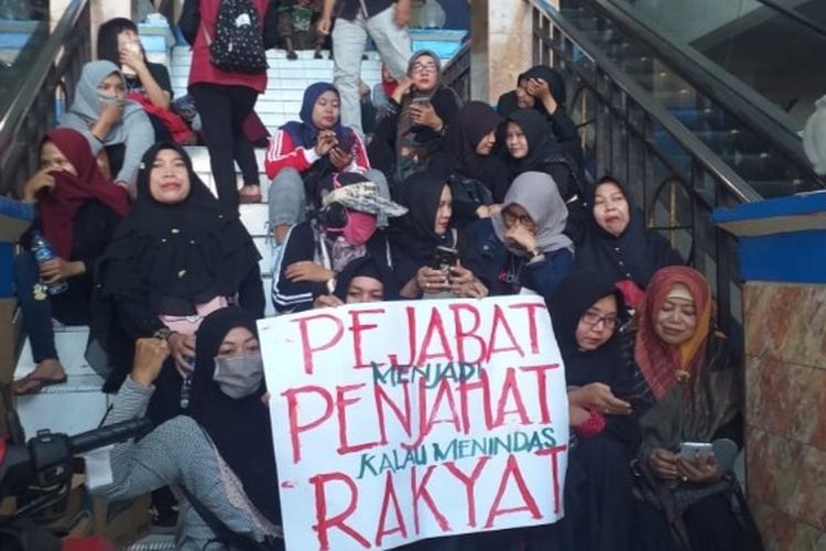 Sejumlah pedagang Pasar Pagi Kota Tegal, Jawa Tengah menggelar aksi damai memprotes pungutan ganda oleh Pemkot Tegal dengan duduk di tangga akses masuk pasar Senin (20/1/2020)